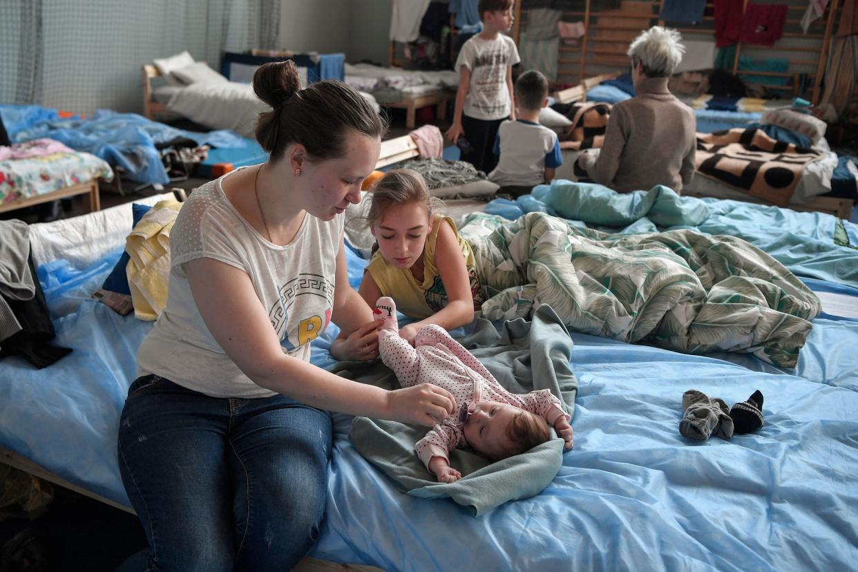 A mother tends to her 2-months old daughter in a temporary shelter in a gym of a high school in Przemysl, near the Ukrainian-Polish border, on March 15, 2022. - More than three million people have now fled Ukraine since Russia invaded on February 24, the United Nations said on March 15, 2022. (Photo by Louisa GOULIAMAKI / AFP) (Photo by LOUISA GOULIAMAKI/AFP via Getty Images)