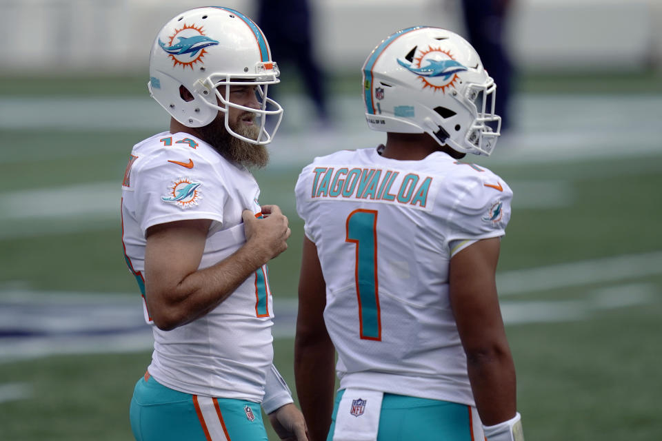 Miami Dolphins quarterbacks Ryan Fitzpatrick (14) and Tua Tagovailoa (1) warm up before an NFL football game against the New England Patriots, Sunday, Sept. 13, 2020, in Foxborough, Mass. (AP Photo/Charles Krupa)