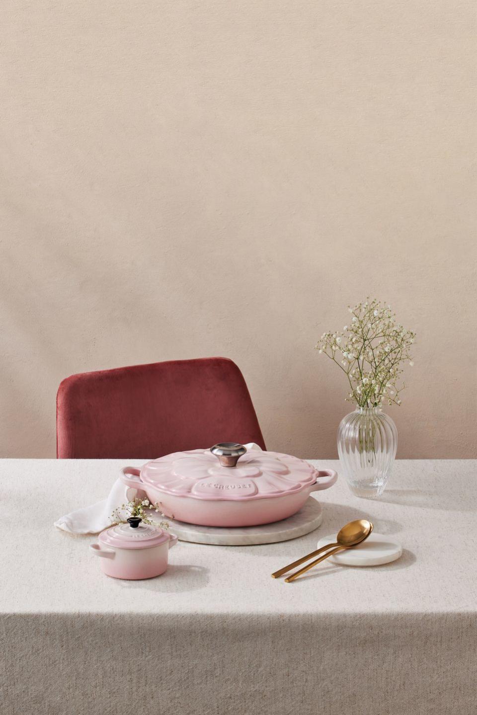 a table with a pink cake and a pink bowl with a flower on it