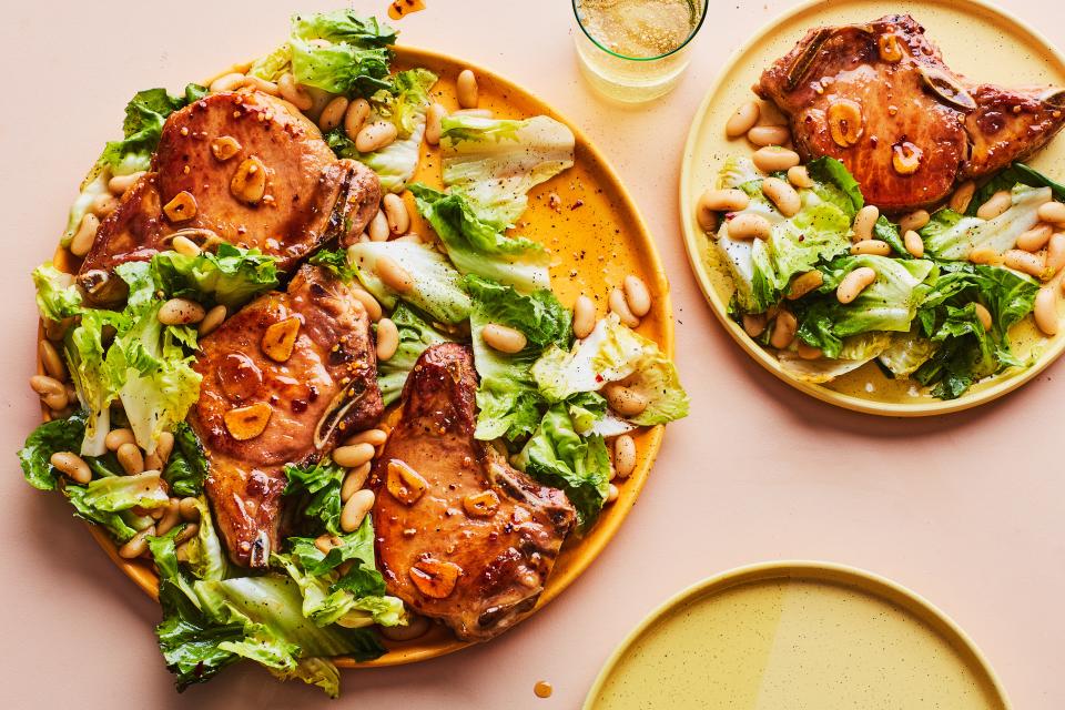 The spicy garlic-honey glaze for the pan-seared pork chops also forms the base of the sauce for the warm escarole-and–white bean salad in this easy one-pan dinner. <a rel="nofollow noopener" href="https://www.epicurious.com/recipes/food/views/hot-honey-pork-chops-with-escarole-and-white-beans?mbid=synd_yahoo_rss" target="_blank" data-ylk="slk:See recipe.;elm:context_link;itc:0;sec:content-canvas" class="link ">See recipe.</a>