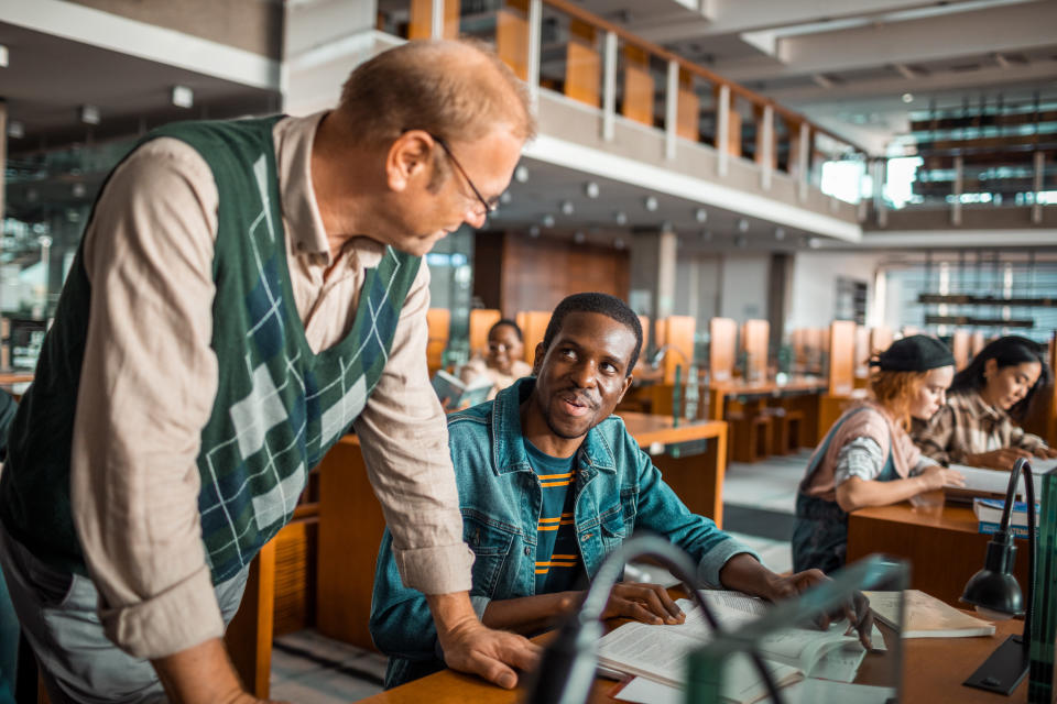 A student and professor talk during a class session