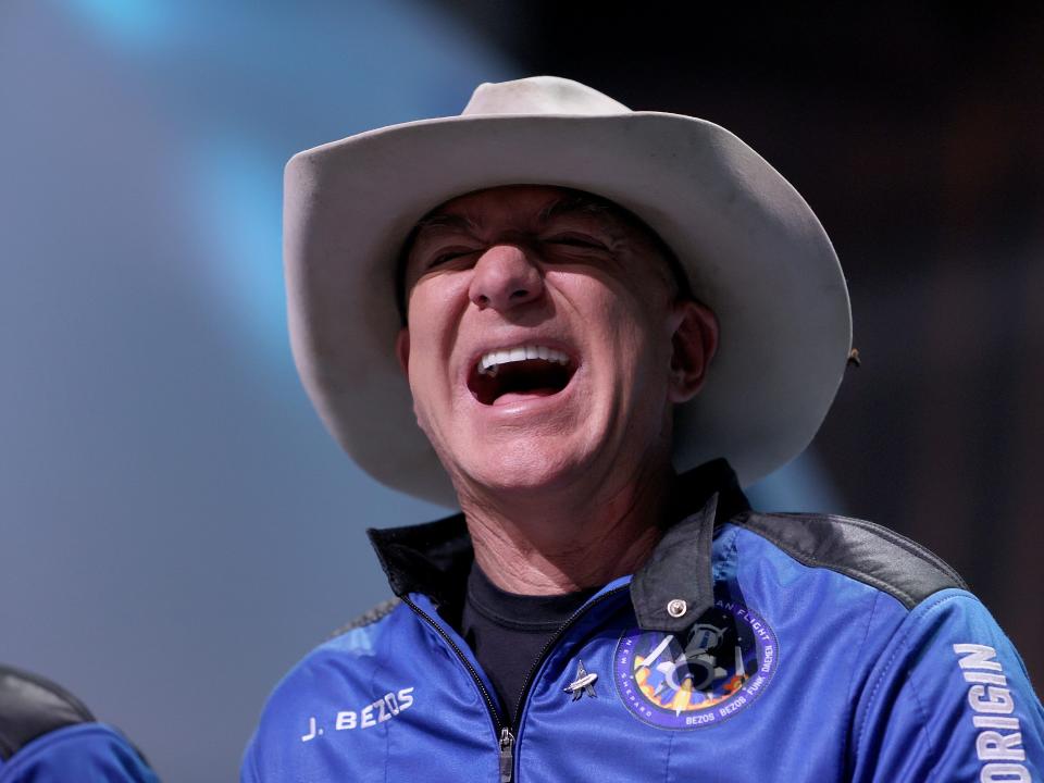 Jeff Bezos laughs wearing a cowboy hat