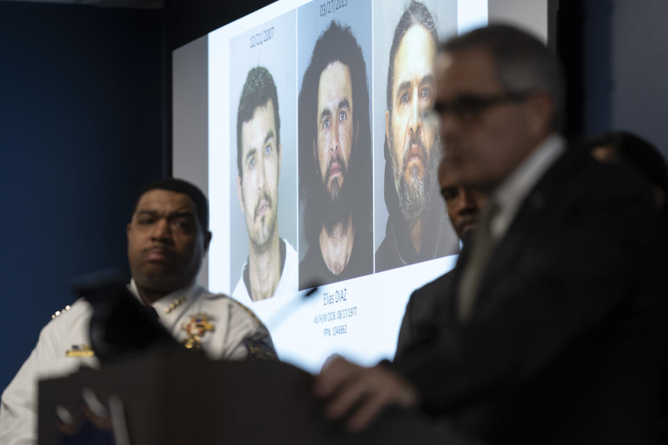 Images of suspect Elias Diaz are projected on a screen between Interim Police Commissioner John Stanford, Jr., left, and District Attorney Larry, right, during a news conference in Philadelphia, Tuesday, Dec. 19, 2023. Authorities say Diaz, accused of slashing people with a large knife while riding a bicycle on a rail trail in Philadelphia is now a person of interest in the cold-case murder of a medical student that occurred among a series of high-profile sexual assaults two decades ago. (AP Photo/Matt Rourke)