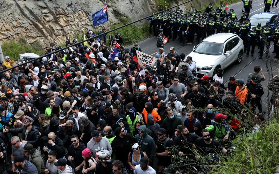 Members of Victoria Police push back protesters after a clash as anti-lockdown protesters take to the streets on September 18, 2021 in Melbourne - Diego Fedele