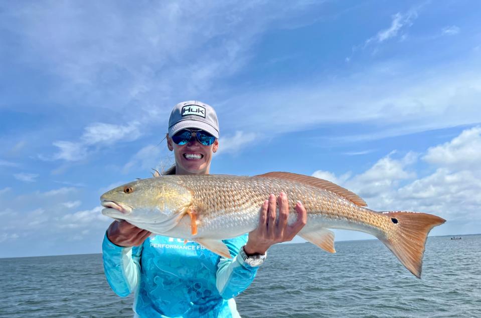 Tammie Mathews of Port St. Joe shows off her catch while fishing with Captain Jordon Todd of Saltwater Obsession Charters in St. Joe Bay.