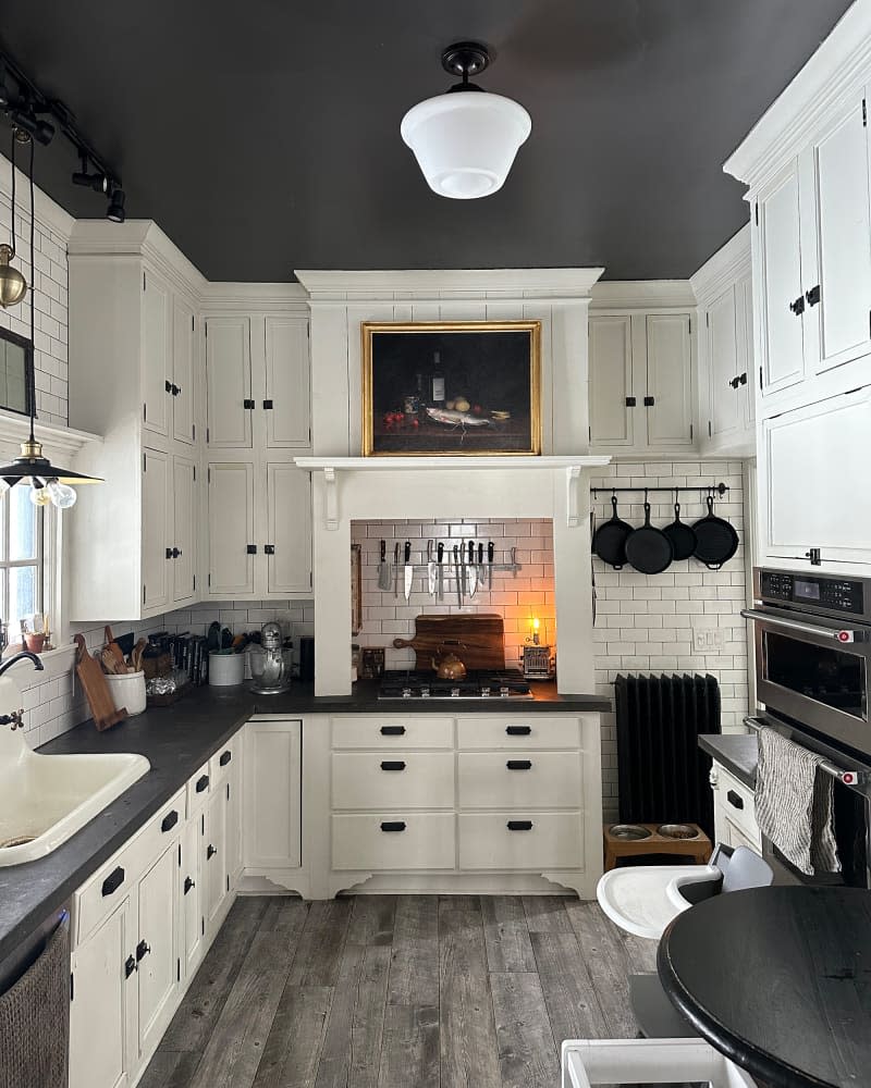 Black painted ceiling in kitchen with white subway tiles.
