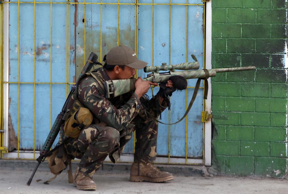 A government soldier looks through the scope of his rifle as residents believed to be hostages of Moro National Liberation Front rebels shout to the soldiers to "stop firing" in downtown Zamboanga city