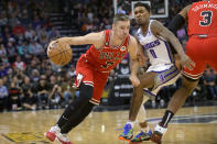 Chicago Bulls guard Goran Dragic (7) drives past Sacramento Kings guard Malik Monk (0) during the first quarter of an NBA basketball game in Sacramento, Calif., Sunday, Dec. 4, 2022. (AP Photo/Randall Benton)