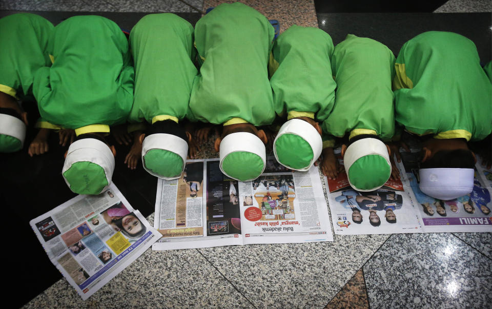 Boys join in prayers at the Kuala Lumpur International Airport for the missing Malaysia Airlines jetliner MH370, Thursday, March 13, 2014, in Sepang, Malaysia. Planes sent Thursday to check the spot where Chinese satellite images showed possible debris from the missing Malaysian jetliner found nothing, Malaysia's civil aviation chief said, deflating the latest lead in the six-day hunt. The hunt for the missing Malaysia Airlines flight 370 has been punctuated by false leads since it disappeared with 239 people aboard about an hour after leaving Kuala Lumpur for Beijing early Saturday. (AP Photo/Wong Maye-E)