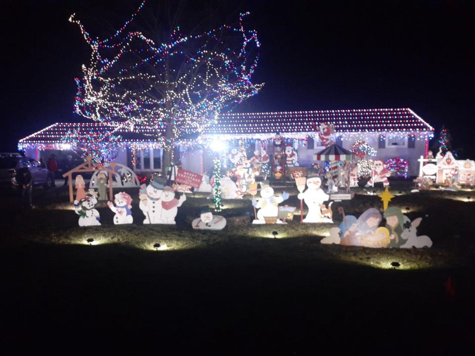 A holiday light display ar 4634 Brookhaven Circle NE in Plain Township features homemade wooden decorations