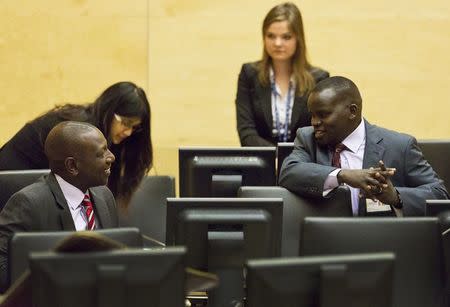 Kenya's Deputy President William Ruto speaks with broadcaster Joshua arap Sang (R) in the courtroom before their trial at the International Criminal Court (ICC) in The Hague in this September 10, 2013 file photo. REUTERS/Michael Kooren/Files