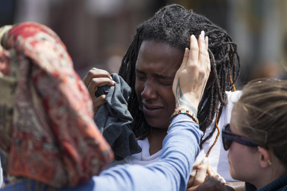 Shameeka Dream, of Baltimore is helped after being sprayed in the eyes with a crowd disbursement during a demonstration after an evening of riots following the funeral of Freddie Gray on Tuesday, April 28, 2015, in Baltimore. Gray died from spinal injuries about a week after he was arrested and transported in a Baltimore Police Department van. (AP Photo/Evan Vucci)
