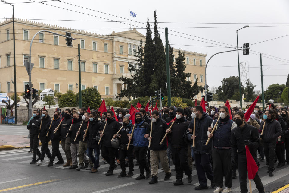 Protesters march in front of the parliament during an anti-government rally at central Syntagma square in Athens, on Saturday, Jan. 22, 2022. Hundreds protesters gathered to protest staff shortages in state heath sector and compulsory coronavirus vaccinations. (AP Photo/Yorgos Karahalis)