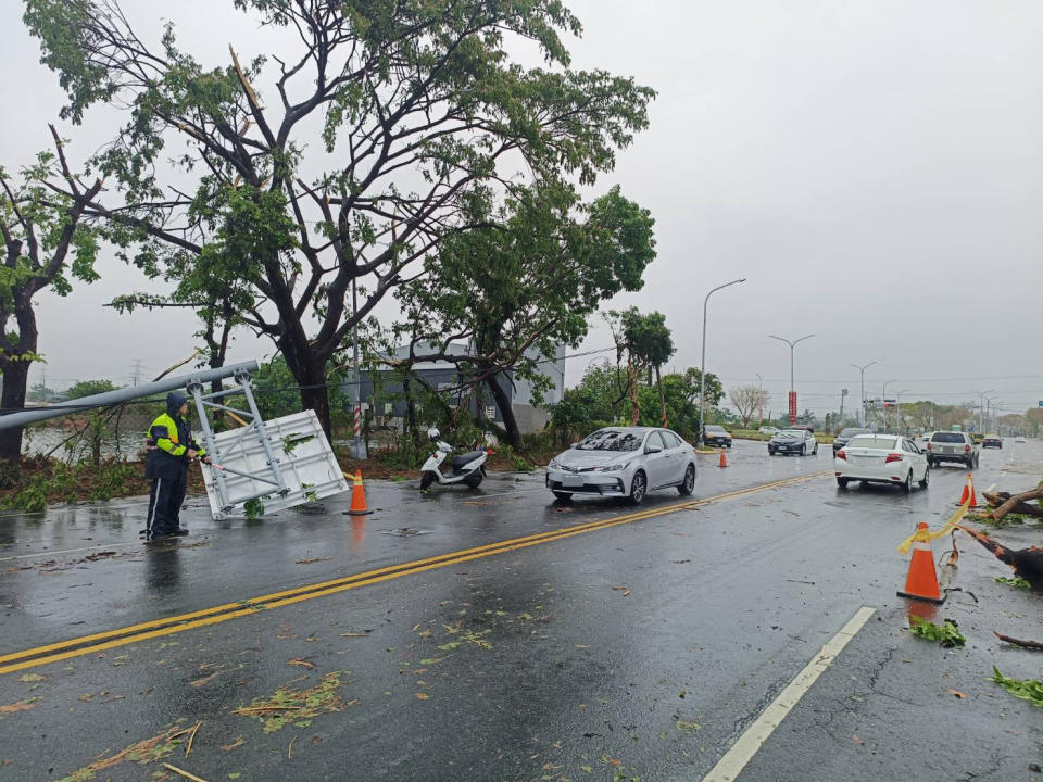 高雄市24日清晨下起大雷雨，湖內區東方路往茄萣區方向有路樹傾倒、路邊標誌桿及電桿斷裂等狀況，造成雙向車道各一線道阻塞，警方已通報台電及相關廠商協處中。（圖／高雄市政府警察局湖內分局提供）