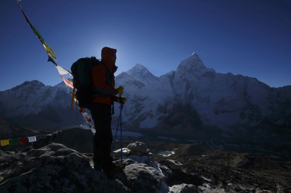 A trekker stands in front of Mount Everest, which is 8,850 meters high (C), at Kala Patthar in Solukhumbu District May 7, 2014. More than 4,000 climbers have reached the summit of Everest, the world's highest peak, since it was first scaled by Sir Edmund Hillary and Tenzing Norgay Sherpa in 1953. In April, an avalanche killed 16 Nepali Sherpa guides who were fixing ropes and ferrying supplies for their foreign clients to climb the 8,850-metre (29,035-foot) peak. The accident - the deadliest in the history of Mount Everest - triggered a dispute between sherpa guides who wanted a climbing ban in honour of their colleagues and the Nepali government that refused to close the mountain. The sherpas staged a boycott, forcing hundreds of foreign climbers to call off their bids to climb Everest. Picture taken May 7, 2014. REUTERS/Navesh Chitrakar (NEPAL - Tags: ENVIRONMENT SOCIETY BUSINESS EMPLOYMENT TRAVEL TPX IMAGES OF THE DAY) ATTENTION EDITORS: PICTURE 44 OF 45 FOR PACKAGE 'AFTER THE AVALANCHE - ASCENT TO EVEREST' TO FIND ALL IMAGES SEARCH 'CHITRAKAR EVEREST'