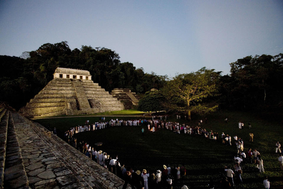 FILE - In this March 10, 2008 file photo, participants of 'Indigenous People to Heal Our Mother Earth'' hold a pre-dawn ceremony at the foot of Mayan ruins in Palenque, Mexico. Mexico's president-elect Andres Manuel Lopez Obrador wants to build a train that would run from Cancun to Palenque, but it's not the first time ambitious rail projects have been proposed: current President Enrique Pena Nieto announced in 2012 he would build a rapid train link connecting the Riviera Maya with Merida. It was cancelled due to a lack of funds. (AP Photo/Alexandre Meneghini, File)