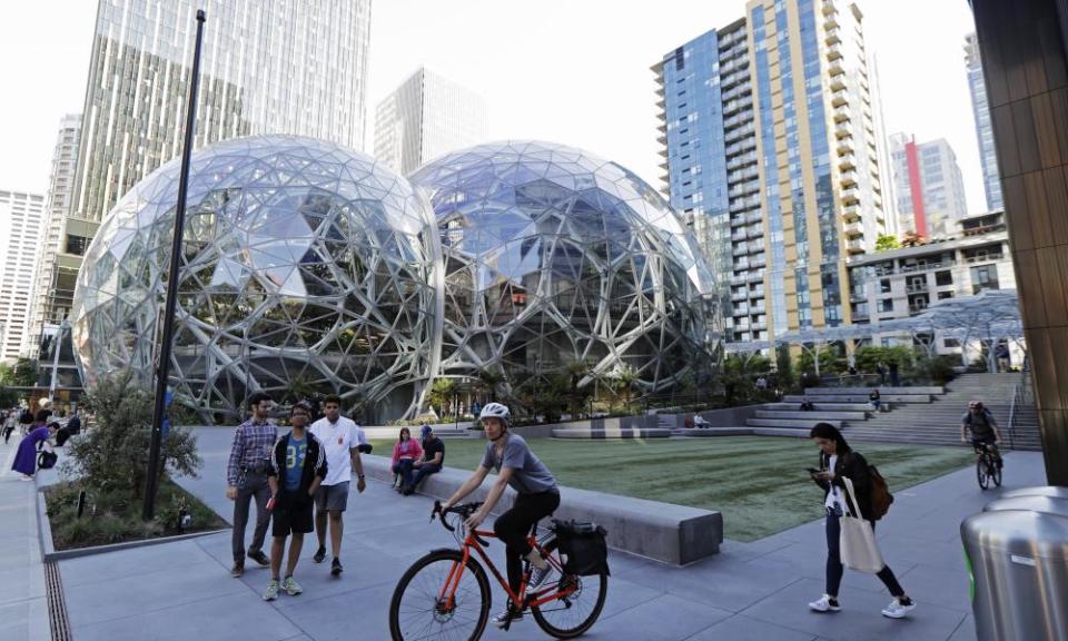 Pedestrians and cyclists gather near the Amazon Spheres, in Seattle. Seattle’s latest tax proposal to combat homelessness takes aim at large businesses such as Amazon that have helped drive the city’s economic boom.