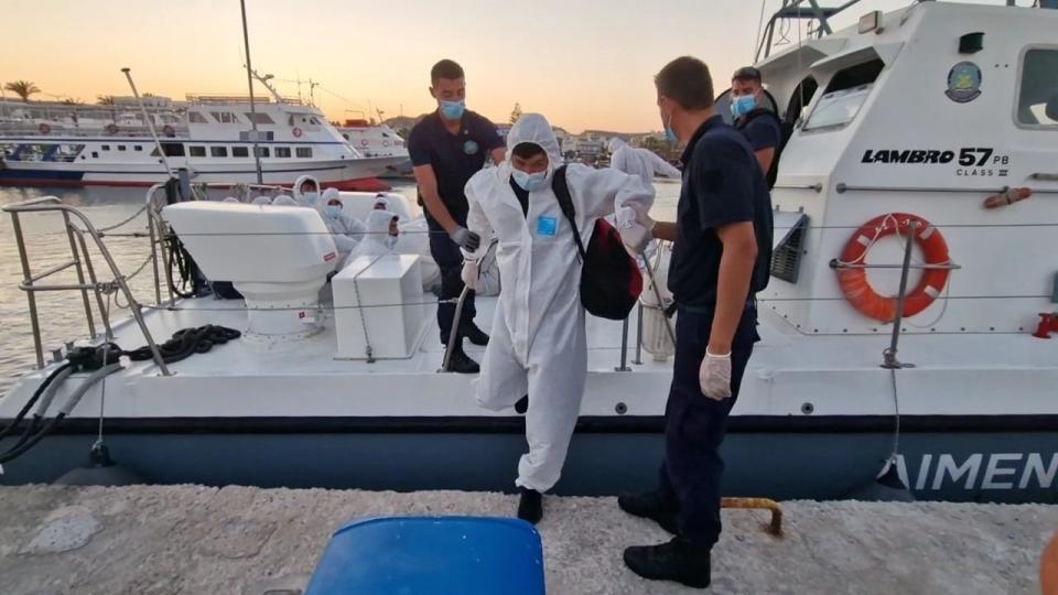 This photo provided by the Hellenic Coast Guard shows migrants arrive at a port on the southeastern Aegean Sea island of Kos, Greece, after a rescue operation on Wednesday, Aug. 10, 2022. Greek authorities conducted a major search and rescue operation Wednesday for dozens of people believed missing at sea east of the island of Karpathos after a boat reportedly carrying up to 80 migrants towards Italy sank during the night. The coast guard said 29 men were rescued 33 nautical miles (38 miles, 61 kilometers) off Karpathos, a southeastern island between Rhodes and Crete. (Hellenic Coast Guard via AP)