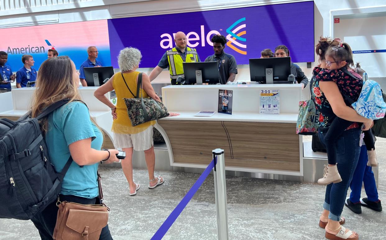 Departing air travelers line up at the checked-baggage counter for Avelo Airlines at Daytona Beach International Airport on June 22, 2023.