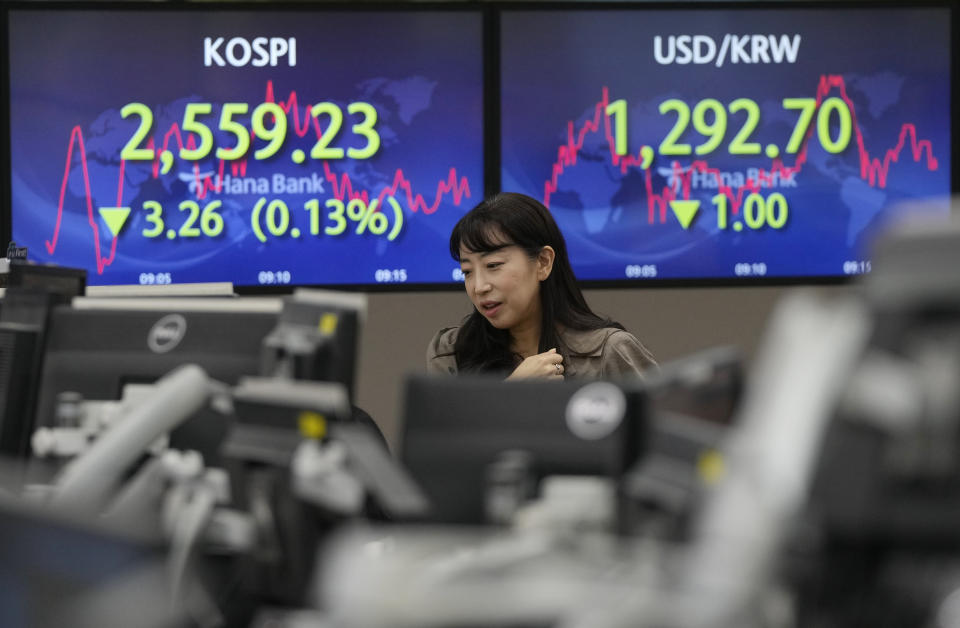 A currency trader watches monitors in front of screens showing the Korea Composite Stock Price Index (KOSPI), top left, and the foreign exchange rate between U.S. dollar and South Korean won at the foreign exchange dealing room of the KEB Hana Bank headquarters in Seoul, South Korea, Wednesday, July 12, 2023. Asian shares were mostly higher on Wednesday after stocks advanced on Wall Street as investors awaited an update on U.S. inflation that will hopefully show a smaller increase in pain for everyone.(AP Photo/Ahn Young-joon)