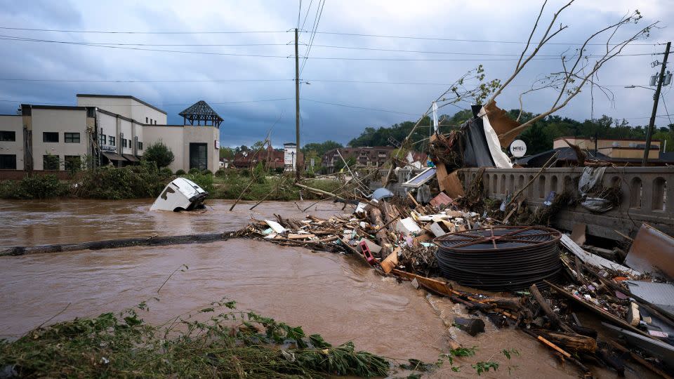 A van sits in floodwaters near Biltmore Village in Asheville, North Carolina, after Hurricane Helene on September 28, 2024. -Sean Rayford/Getty Images