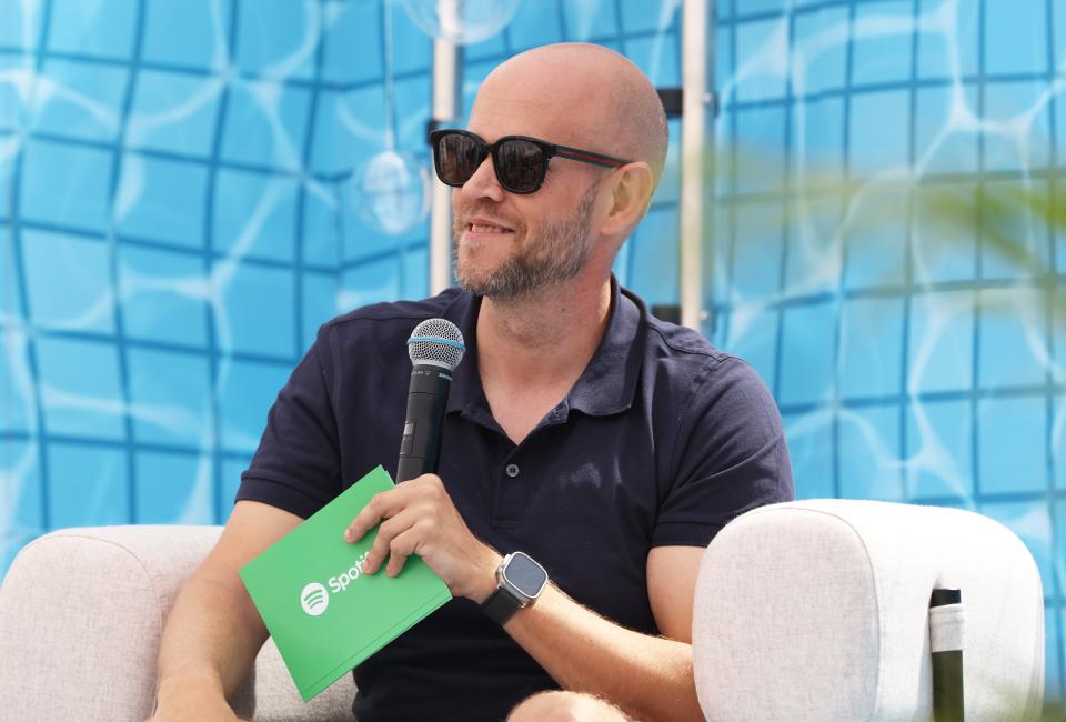 Daniel Ek wearing sunglasses and holding a microphone.