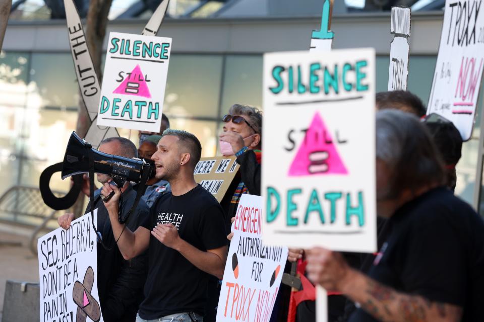 Health care and LGBTQ rights activists hold signs as they stage a protest outside of the San Francisco Federal Building on Aug. 08.