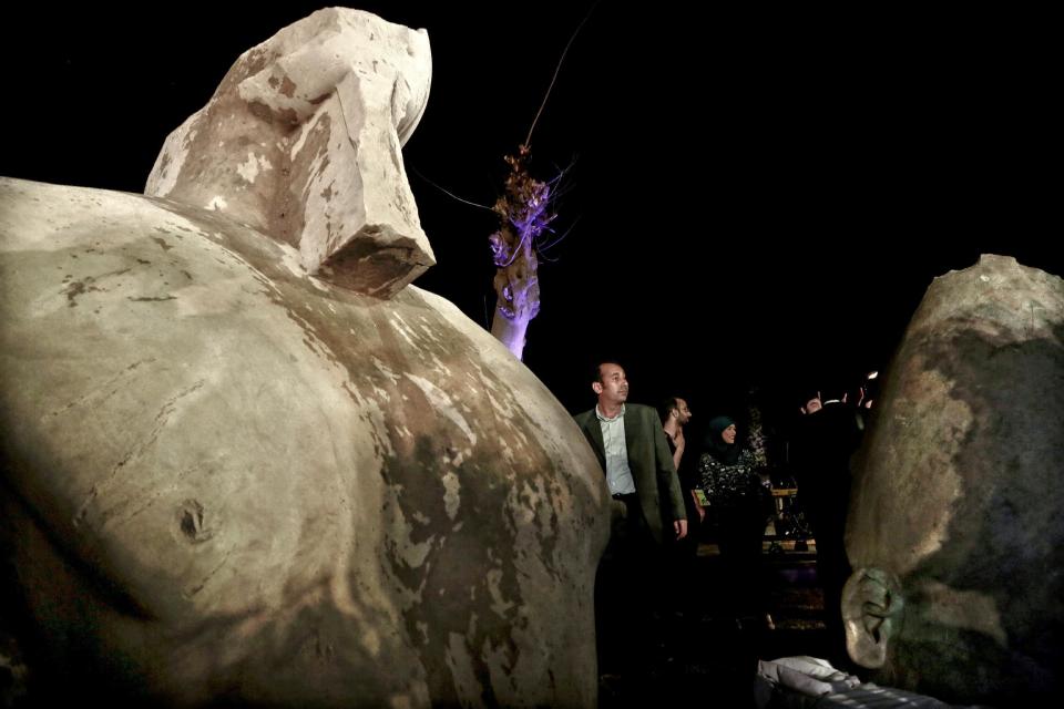 People gather around stone parts of the statue of King Psamtek l after a press conference at the Egyptian museum in Cairo, Thursday, March 16, 2017. Egypt's antiquities minister Khaled el-Anani, told at a news conference that the colossus discovered last week in an eastern Cairo suburb almost certainly depicts Psamtek I, who ruled Egypt between 664 and 610 B.C. (AP Photo/Nariman El-Mofty)