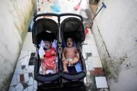 Five-month-old twins, Laura (L) and Lucas lie in a buggy at an entrance of their house in Santos, Sao Paulo state, Brazil April 20, 2016. REUTERS/Nacho Doce
