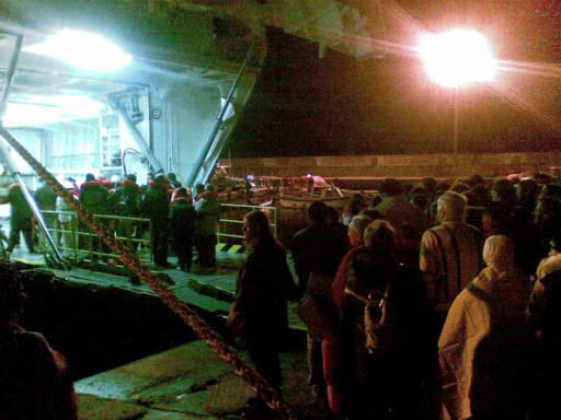 The passangers of the Costa Concordia take a ferry on January 14, 2012, after the cruise ship ran aground and keeled over off the Isola del Giglio, last night. Three people died and about 70 were missing after an Italian cruise ship with more than 4,000 people on board ran aground and keeled over, sparking scenes of panic. The Costa Concordia was on a trip around the Mediterranean when it apparently hit a reef near the island of Giglio on Friday, only a few hours into its voyage, as passengers were sitting down for dinner. AFP PHOTO / Giorgio Fanciulli / Giglionews