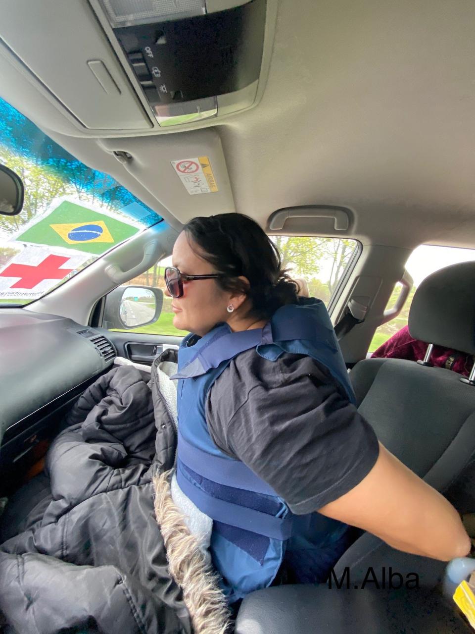 Adelia Sobrenome strapped into body armor while she and Mike Alba travel between checkpoints.