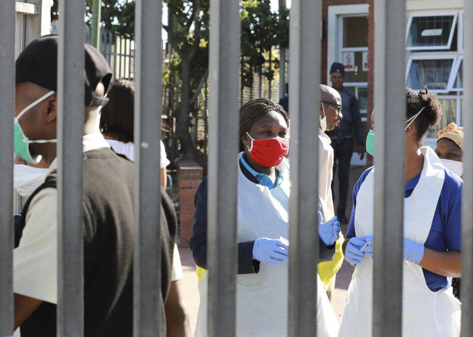 In this photo taken Thursday, April 2, 2020 medical workers prepare to test people for COVID-19 at a testing clinic in Khayelitsha, Cape Town, South Africa. South Africa, one of the world's most unequal countries with a large population vulnerable to the new coronavirus, may have an advantage in the coronavirus outbreak, honed during years battling HIV and tuberculosis: the know-how and infrastructure to conduct mass testing. (AP Photo/Nardus Engelbrecht)