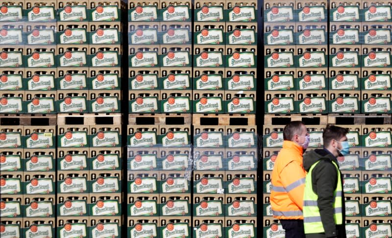 Workers walk past crates of beer on the yard of Plzensky Prazdroj brewery in Plzen