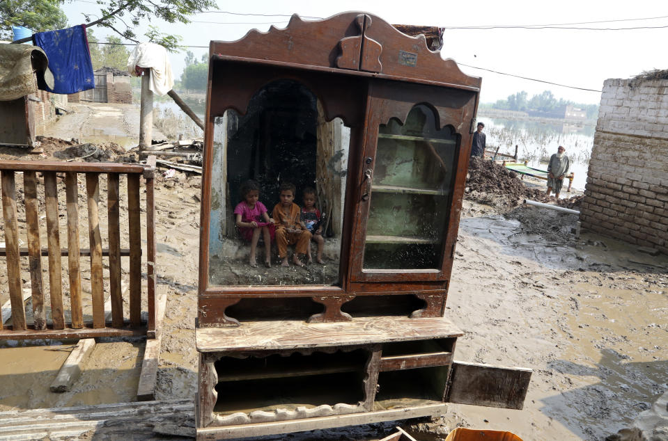 Children are reflected in a mirror near their flood-hit home, in Charsadda, Pakistan, Wednesday, Aug. 31, 2022. Officials in Pakistan raised concerns Wednesday over the spread of waterborne diseases among thousands of flood victims as flood waters from powerful monsoon rains began to recede in many parts of the country. (AP Photo/Mohammad Sajjad)