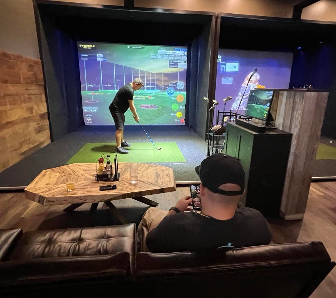 Dan Marrone, 29, watches Vinnie Iannone, 28, play virtual golf at the Topgolf Swing Suite at The Brew Kettle in Canton.