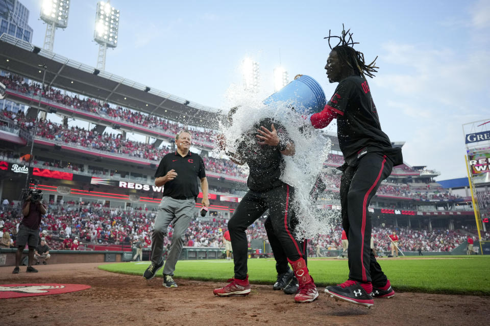 Cincinnati Reds' Spencer Steer, middle, is doused by Will Benson, back, and Elly De La Cruz after hitting a game-winning, two-run home run against the San Diego Padres during the 11th inning of a baseball game in Cincinnati, Friday, June 30, 2023. (AP Photo/Aaron Doster)