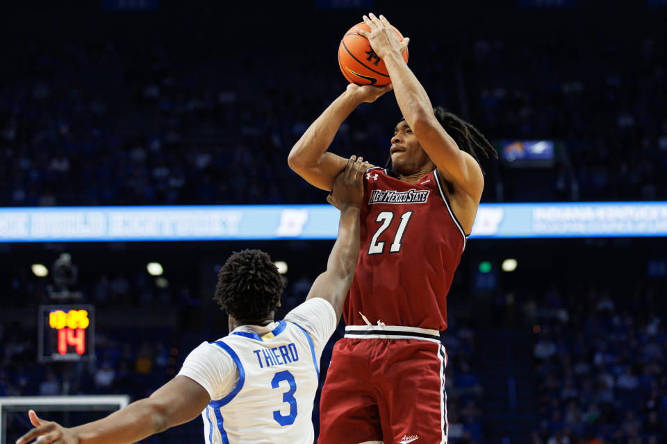 Nov 6, 2023; Lexington, Kentucky, USA; New Mexico State Aggies forward Robert Carpenter (21) shoots the ball against Kentucky Wildcats guard Adou Thiero (3) during the first half at Rupp Arena at Central Bank Center. Mandatory Credit: Jordan Prather-USA TODAY Sports