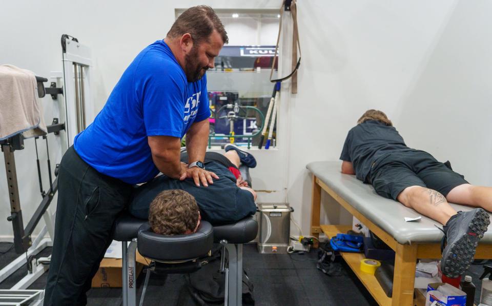 Ascension St. Vincent Sports Performance athletic trainer Ryan Galloy (left) works on the back of Keith Gummer, an inside rear pit crew member on the team of Andretti Autosport driver Colton Herta, on Tuesday, May 9, 2023, inside the gym at Andretti's Indianapolis headquarters.