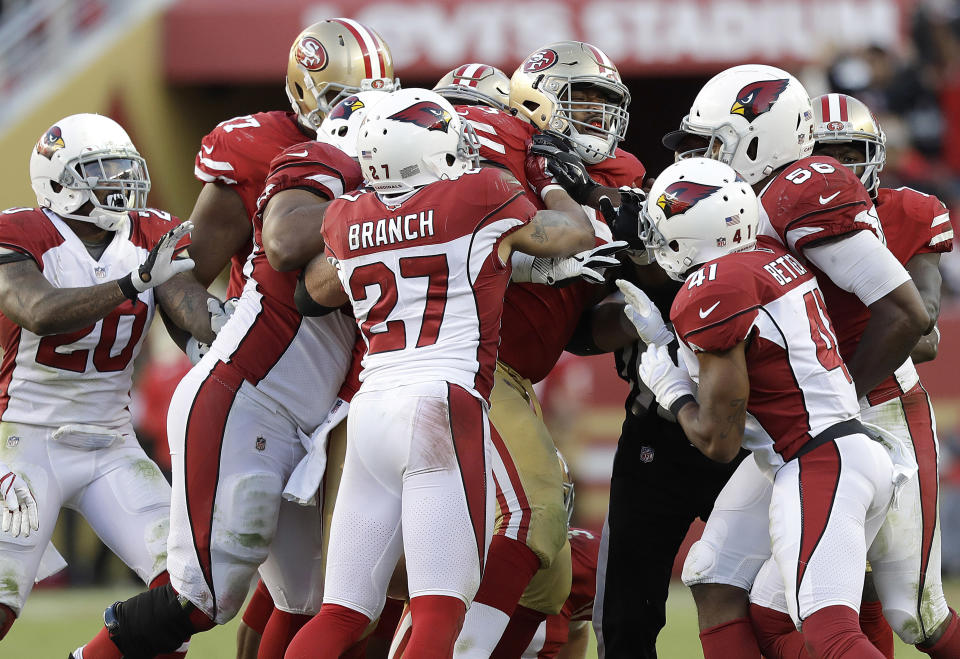 San Francisco 49ers offensive guard Laken Tomlinson, center, shoves Arizona Cardinals players during the second half on Sunday. (AP)