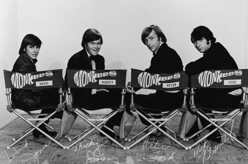 Portrait Of The MonkeesPromotional portrait of popular music and television group the Monkees, dressing in tuxedos and they as they sit in folding chair and look over their shoulders, early 1970s. From left, British musician and actor Davy Jones, and American musician and actors Mickey Dolenz, Peter Tork, and Michael Nesmith. The chairs are labeled with the band's guitar-shaped logo and the name of each member. (Getty Images)