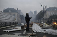A French riot police holds a position as other, right, advance after clearing a barricade during a demonstration in Bourges, central France, Saturday, Jan. 12, 2019. Paris brought in armored vehicles and the central French city of Bourges shuttered shops to brace for new yellow vest protests. The movement is seeking new arenas and new momentum for its weekly demonstrations. Authorities deployed 80,000 security forces nationwide for a ninth straight weekend of anti-government protests. (AP Photo/Rafael Yaghobzadeh)