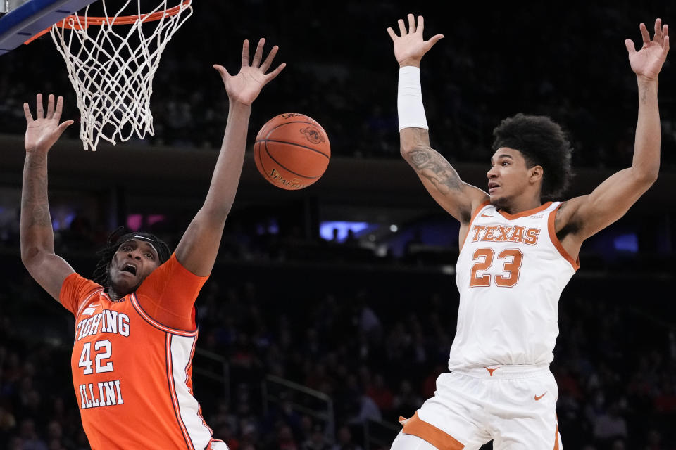 Texas' Dillon Mitchell (23) fouls Illinois' Dain Dainja (42) during the second half of the team's NCAA college basketball game in the Jimmy V Classic, Tuesday, Dec. 6, 2022, in New York. (AP Photo/John Minchillo)