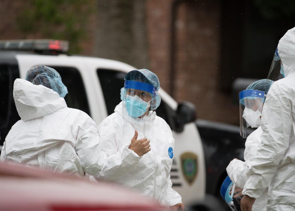 Emergency personnel don PPE before entering the home where more than 90 undocumented immigrants were found on the 12200 block of Chessington Drive, Friday, April 30, 2021, in Houston. A Houston Police official said the case will be handled by federal authorities and that some of the people inside the house were exhibiting COVID-19 symptoms.