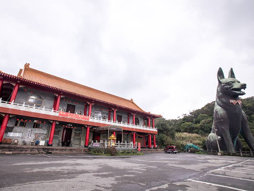 新十八王公廟位於半山腰，四周景緻優美，其中最大特色是，廟旁蹲坐一隻約有十層樓高的「黑龍義犬」塑像。   圖：取自新北市觀光旅遊網