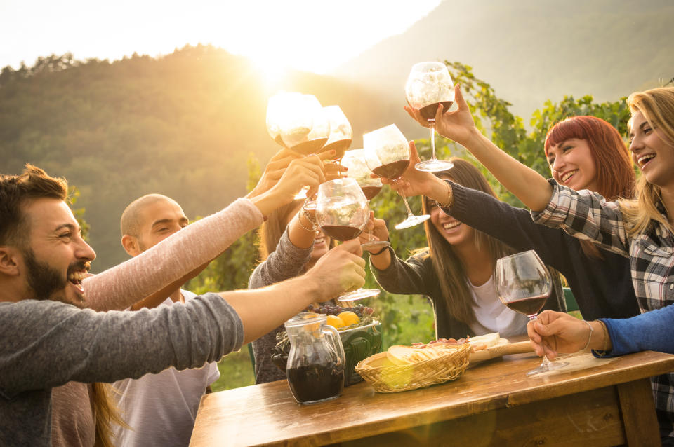 People toasting with wine glasses as the sun sets. A scene that might play out if you win Lotto.