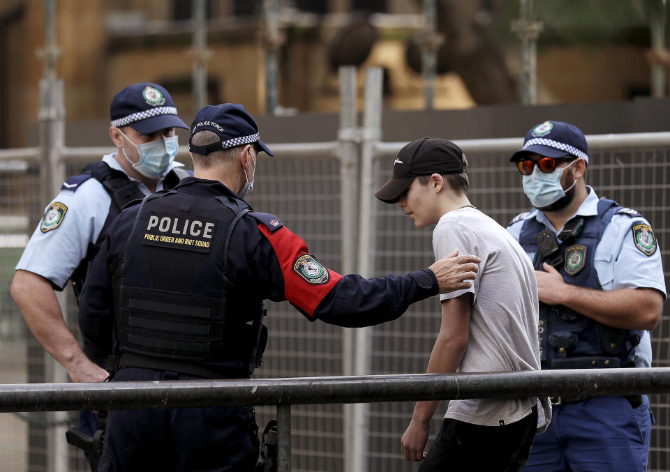 Police take away a man as protesters gather in Sydney, Saturday, June 13, 2020, during a day of demonstrations across Australia in support of the Black Lives Matter movement and refugee rights. Protesters in Sydney, Adelaide and Perth were urged to stay away by government officials concerned about the risk of spreading the new coronavirus. (AP Photo/Rick Rycroft)