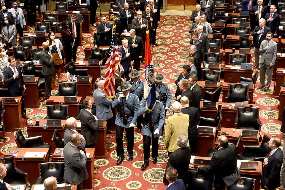 Members of the Missouri House and Senate stand at attention as the Missouri Highway Patrol Honor Guard display the Colors on Wednesday at Gov. Mike Parson’s State of the State address.