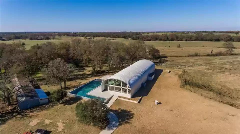curved metal house with wraparound pool