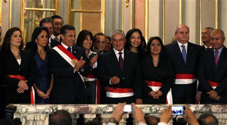 Peru's President Ollanta Humala (3nd L), First Lady Nadine Heredia (2nd L), new Prime Minister Cesar Villanueva (C) and members of the cabinet wave after the swearing-in ceremony of new members of cabinet at the government palace in Lima, October 31, 2013. REUTERS/Mariana Bazo