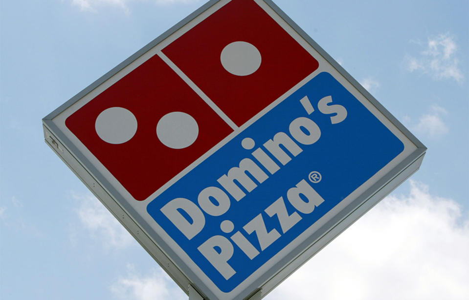 A Domino's pizza logo is seen on a sign on a sunny day. 